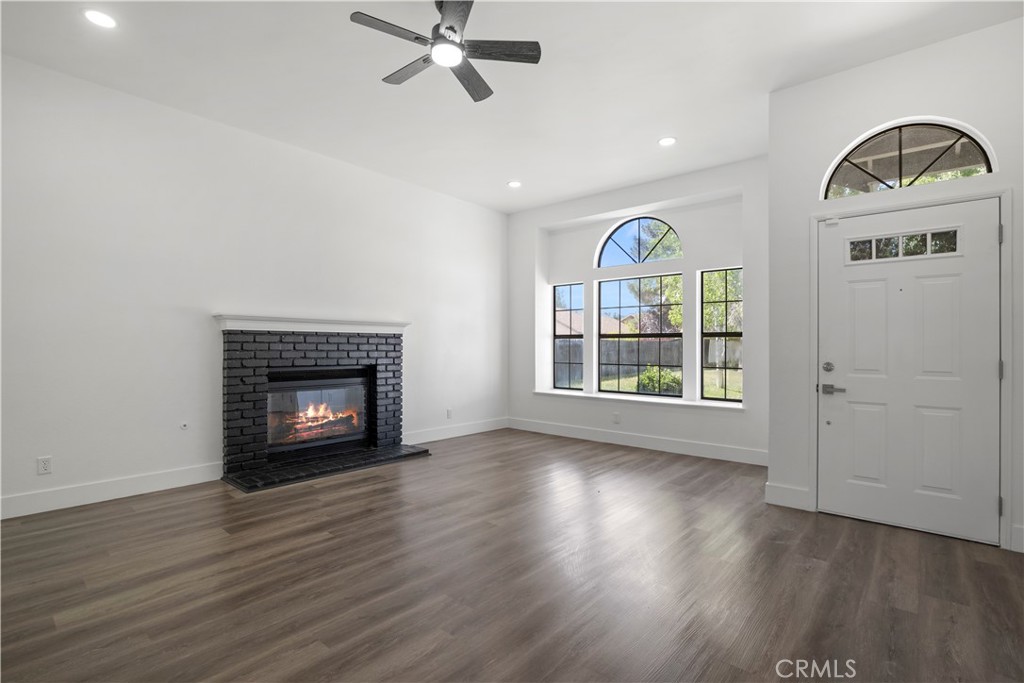 4225 Saddleback Road Palmdale, CA 93552 - Photo 15 of 61 an empty room with wooden floor a fireplace and a window