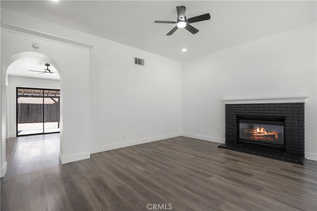 4225 Saddleback Road Palmdale, CA 93552 - Photo 16 of 61 a view of an empty room with wooden floor fireplace and a window