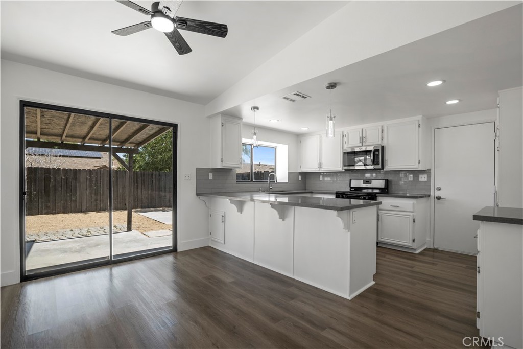 4225 Saddleback Road Palmdale, CA 93552 - Photo 19 of 61 a kitchen with stainless steel appliances granite countertop a refrigerator a sink and white cabinets