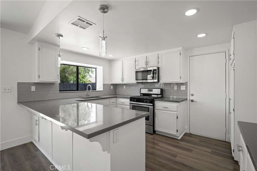 4225 Saddleback Road Palmdale, CA 93552 - Photo 23 of 61 a kitchen with stainless steel appliances granite countertop a sink stove and refrigerator