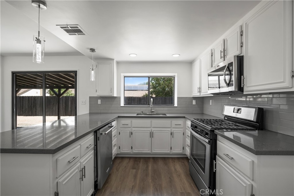 4225 Saddleback Road Palmdale, CA 93552 - Photo 25 of 61 a kitchen with stainless steel appliances granite countertop a sink a stove and cabinets