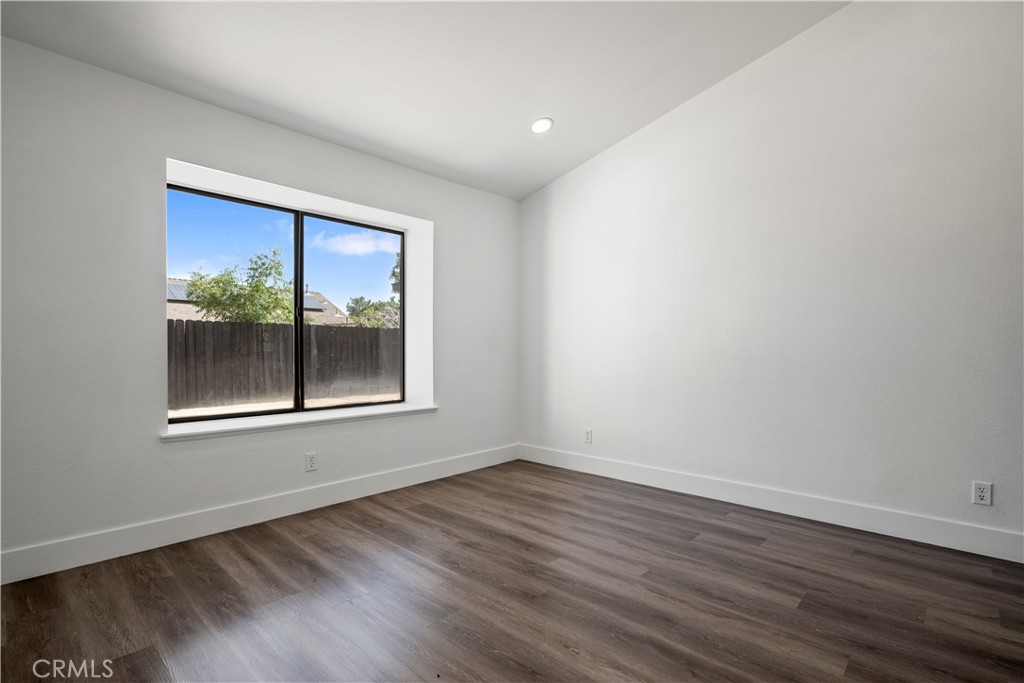 4225 Saddleback Road Palmdale, CA 93552 - Photo 31 of 61 a view of an empty room with wooden floor and a window