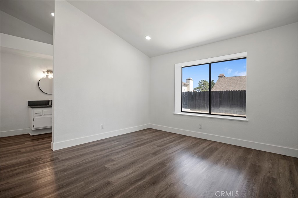 4225 Saddleback Road Palmdale, CA 93552 - Photo 32 of 61 a view of an empty room with wooden floor kitchen view and a window