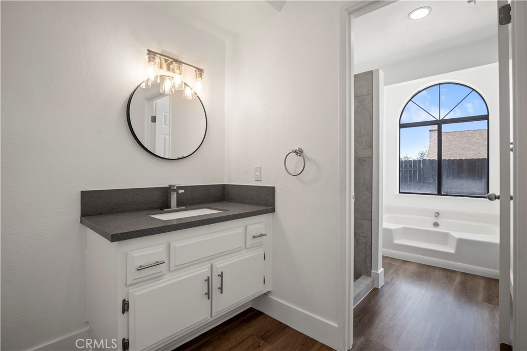 4225 Saddleback Road Palmdale, CA 93552 - Photo 35 of 61 a en suite bathroom with a granite countertop sink and a mirror