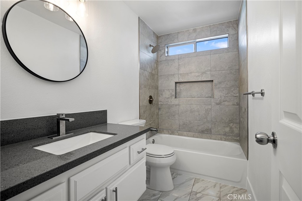 4225 Saddleback Road Palmdale, CA 93552 - Photo 40 of 61 a bathroom with a granite countertop sink mirror toilet and bathtub