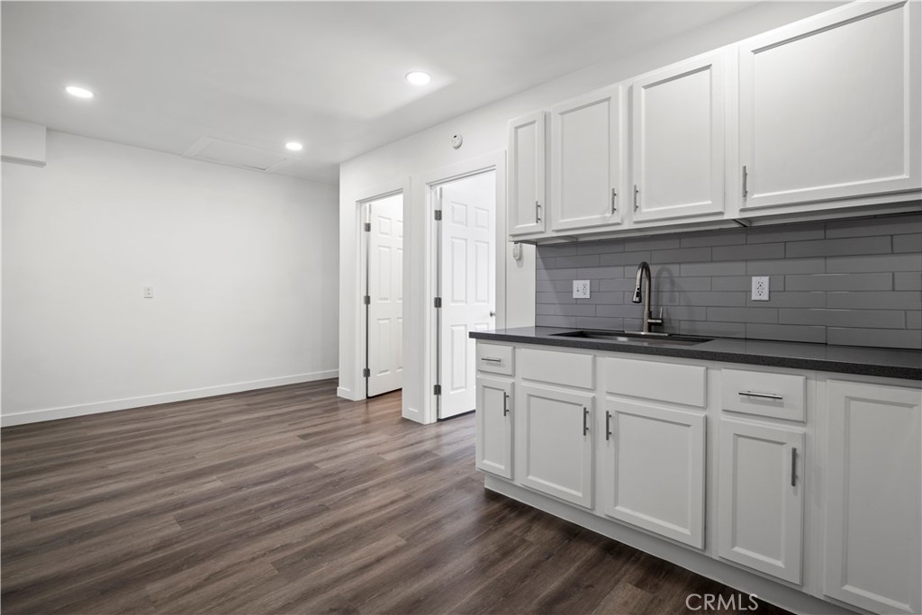 4225 Saddleback Road Palmdale, CA 93552 - Photo 54 of 61 a kitchen with stainless steel appliances granite countertop a sink and cabinets with wooden floor
