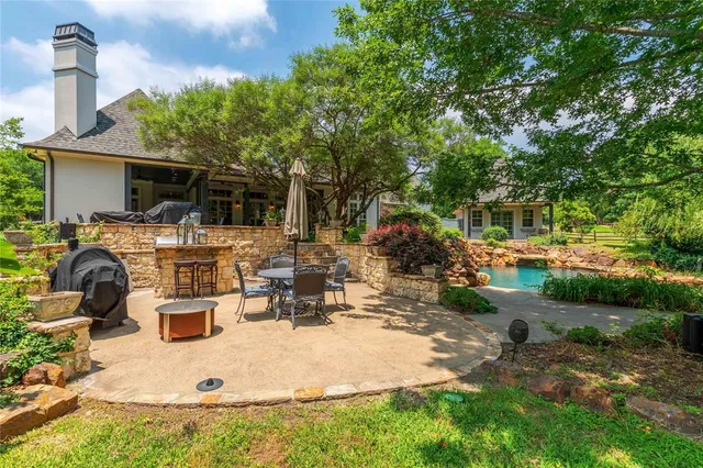 a view of a patio with table and chairs under an umbrella with wooden fence