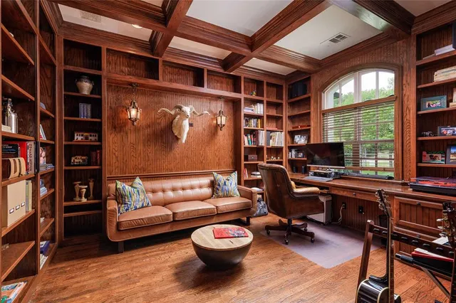 a living room with furniture a piano and a bookshelf