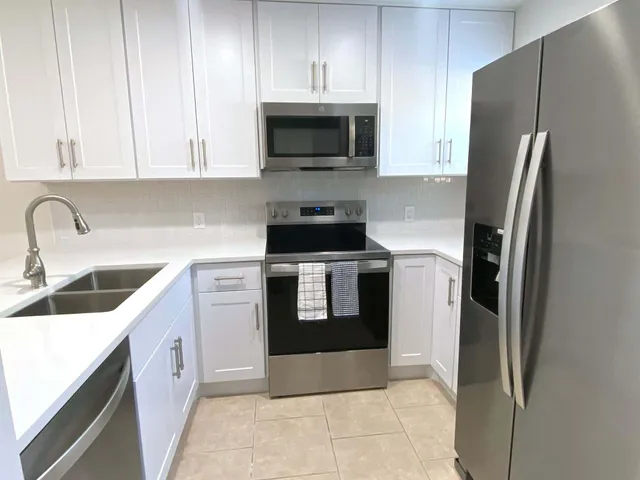 a kitchen with stainless steel appliances granite countertop a refrigerator stove and sink
