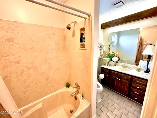 a bathroom with a bathtub sink and mirror