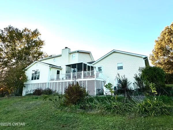 a view of house with a yard and potted plants