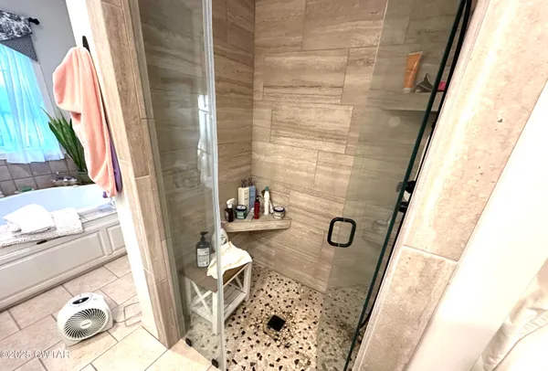 a bath tub sitting next to a bathroom sink and a mirror