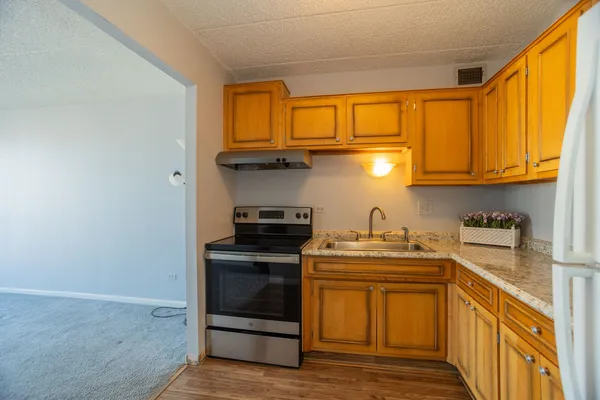 a kitchen with stainless steel appliances granite countertop a sink stove and cabinets