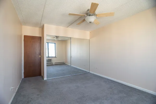 an empty room with a ceiling fan and a window