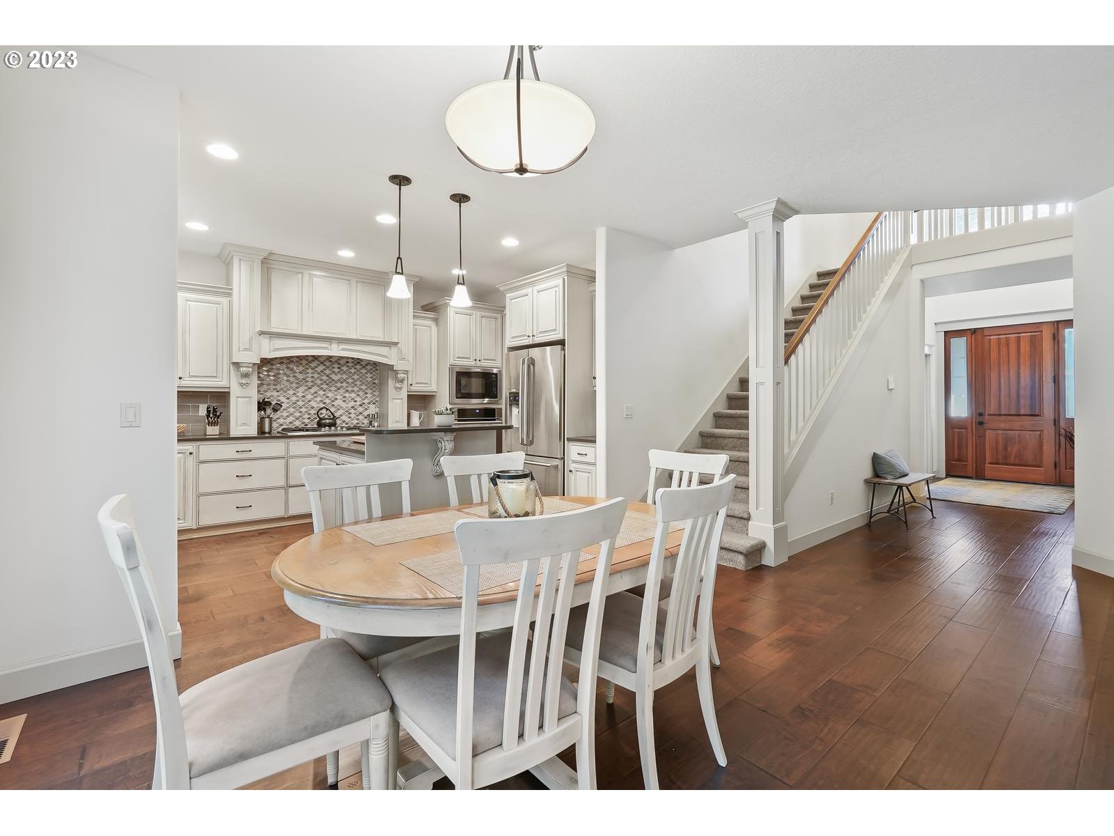 4845 Upper Drive Lake Oswego, OR 97035 - Photo 14 of 35 a kitchen with stainless steel appliances kitchen island granite countertop a dining table chairs and white cabinets