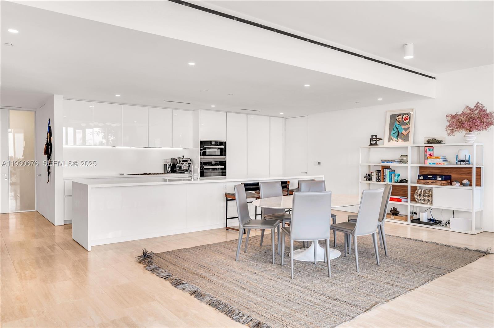a living room with stainless steel appliances furniture a dining table and view of kitchen