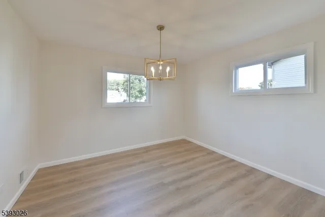 an empty room with windows and ceiling fan view