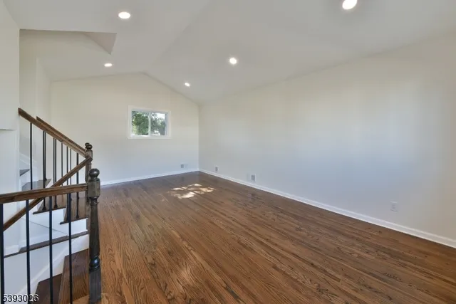 a view of a livingroom with wooden floor and staircase