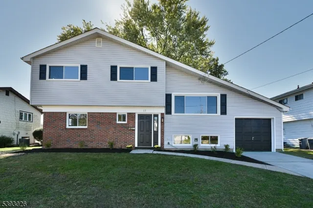 a view of a yard in front of a house with large windows
