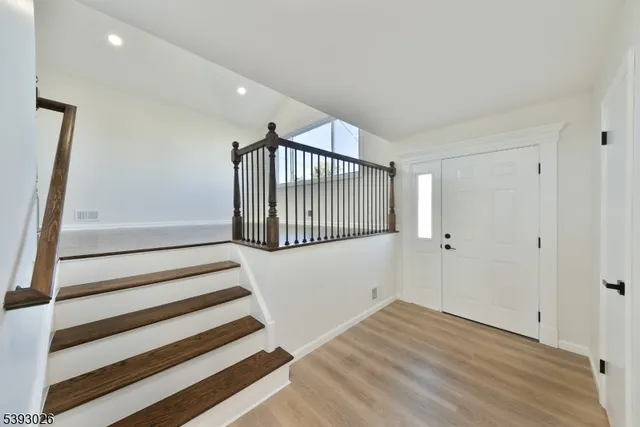 a view of a room with wooden floor and white walls