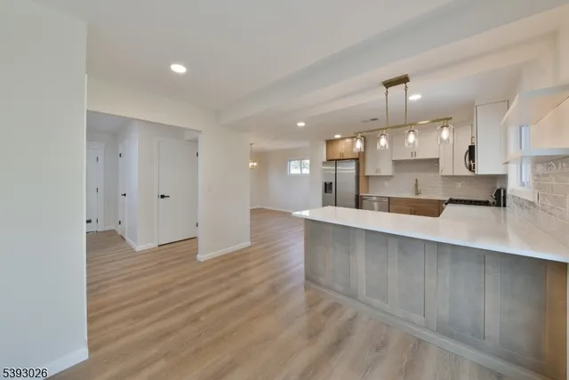 a view of kitchen with kitchen island granite countertop living room and fireplace