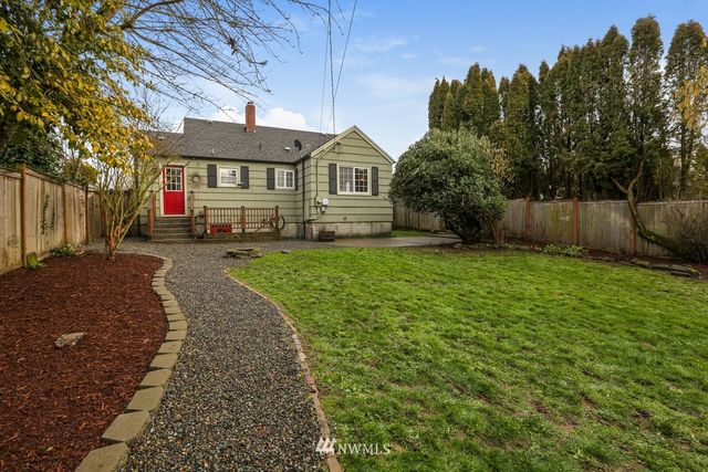 a front view of a house with a yard and trees