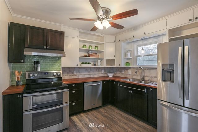 a kitchen with stainless steel appliances granite countertop a stove refrigerator and cabinets