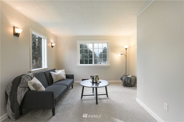 a living room with furniture a window and a potted plant