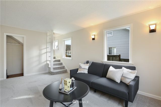a living room with furniture couches and a dining table with wooden floor