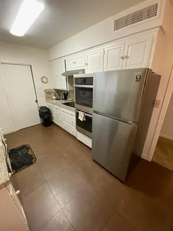 a kitchen with a refrigerator and a stove top oven