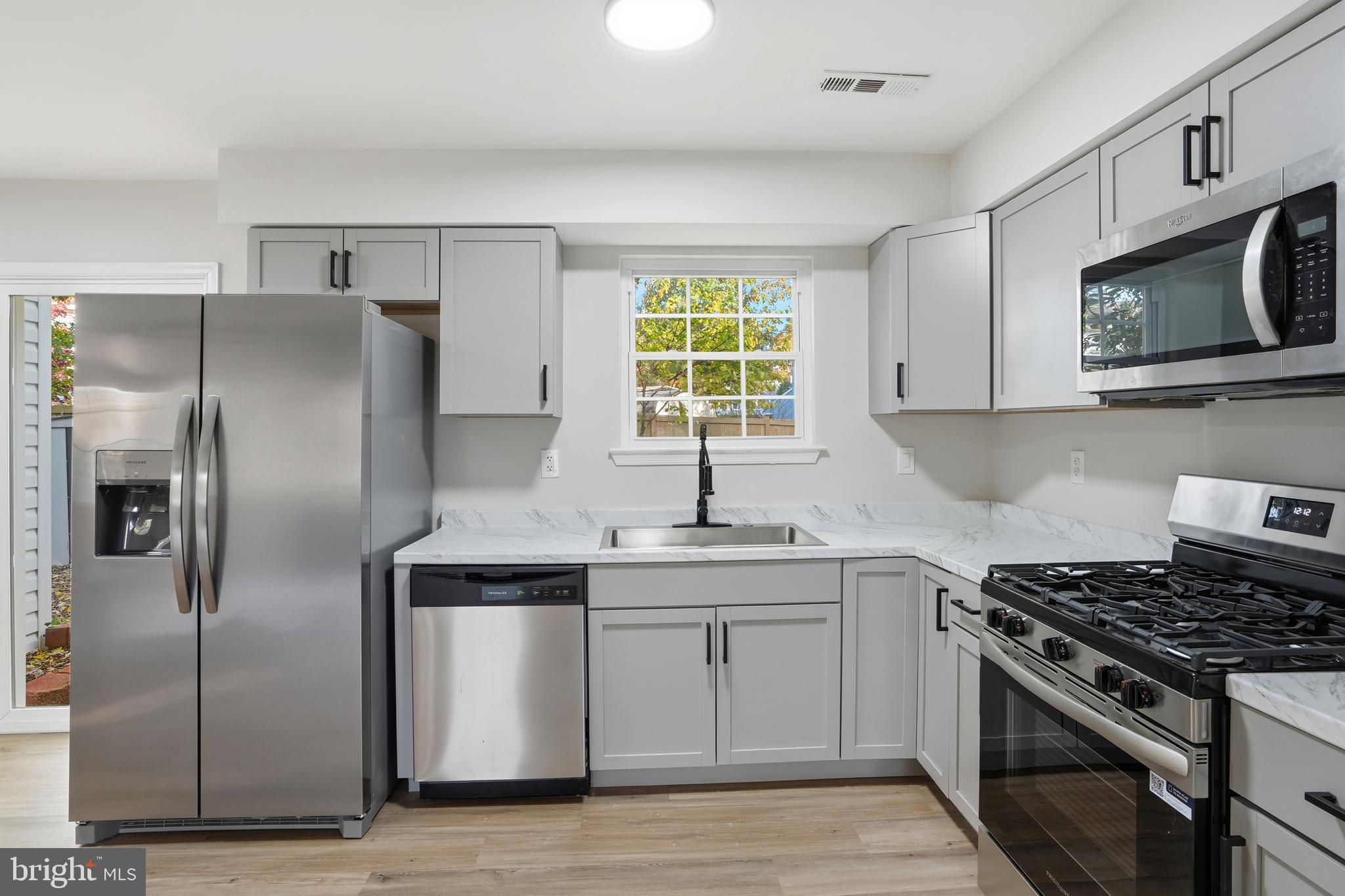 13357 Pelican Road Woodbridge, VA 22193 - Photo 18 of 48 a kitchen with stainless steel appliances granite countertop a stove a sink and a refrigerator