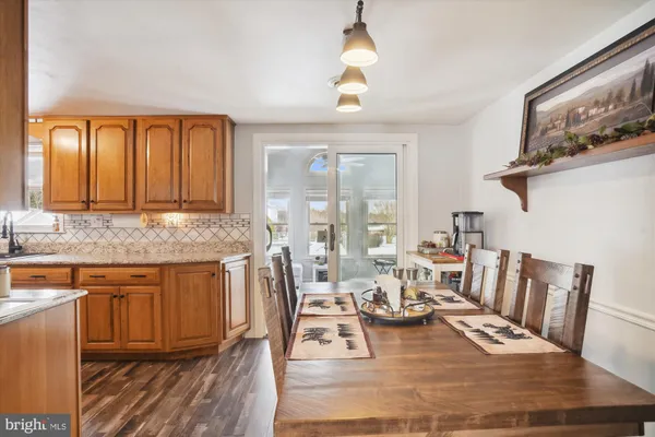a kitchen with a stove a sink dishwasher and a dining table with kitchen view