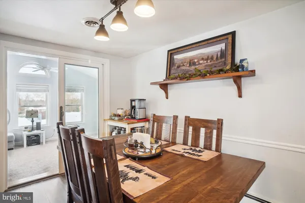 a view of a dining room with furniture a chandelier and wooden floor