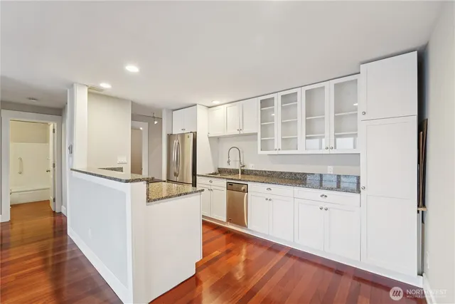 a kitchen with granite countertop a refrigerator and a sink