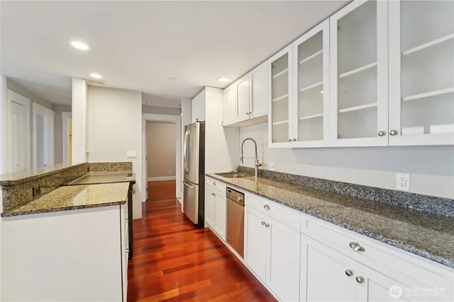 a large kitchen with granite countertop a sink and dishwasher with a granite countertops next to a window