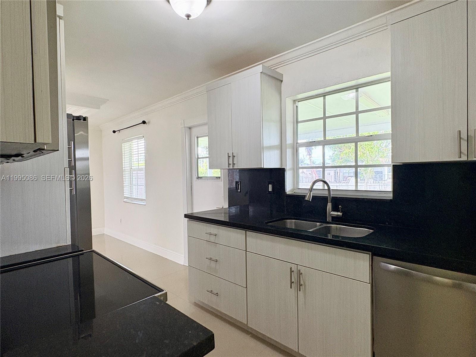 11315 Southwest 58th Terrace Miami, FL 33173 - Photo 13 of 26 a kitchen with a sink window and cabinets
