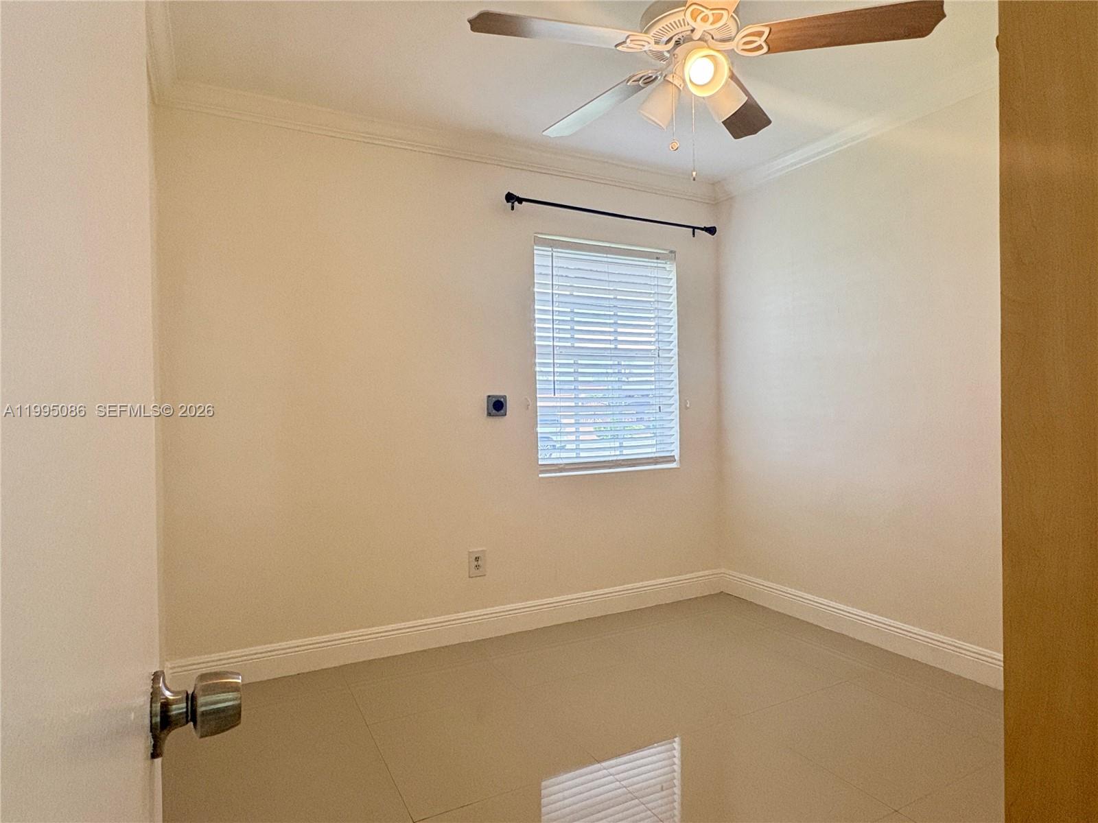 11315 Southwest 58th Terrace Miami, FL 33173 - Photo 20 of 26 an empty room with a window and a fan