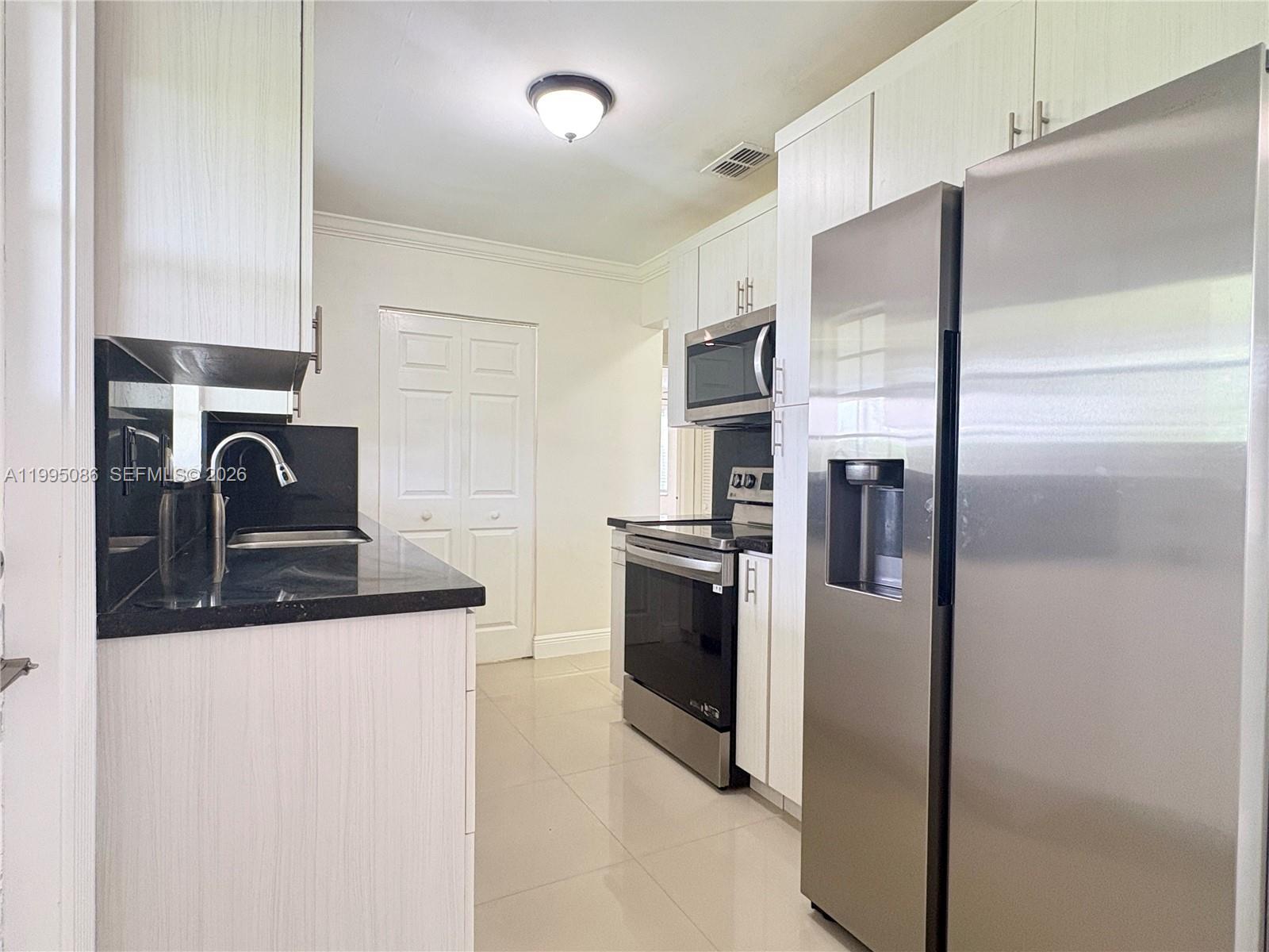 11315 Southwest 58th Terrace Miami, FL 33173 - Photo 10 of 26 a kitchen with a refrigerator sink and stove
