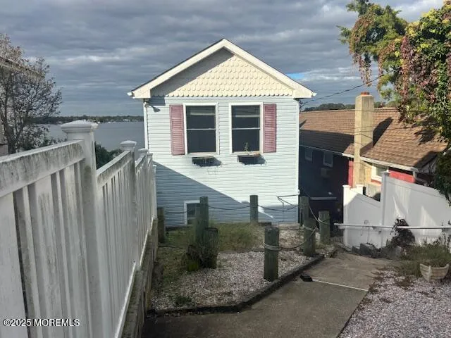 a view of a house with a small yard and wooden fence