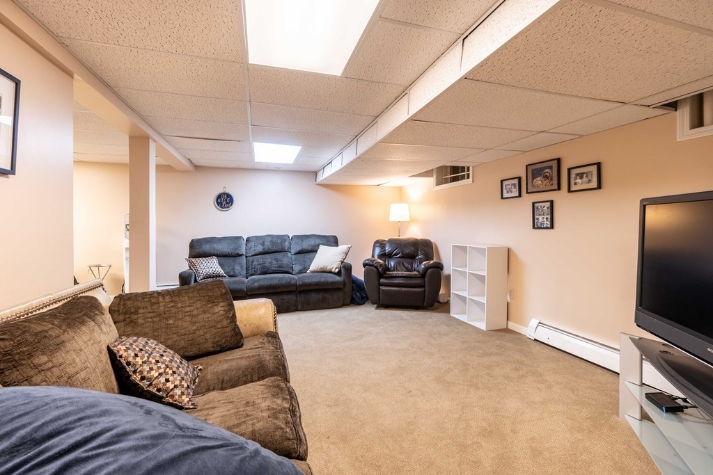 584 Dutton Road Sudbury, MA 01776 - Photo 24 of 29 a living room with furniture a flat screen tv and a fireplace