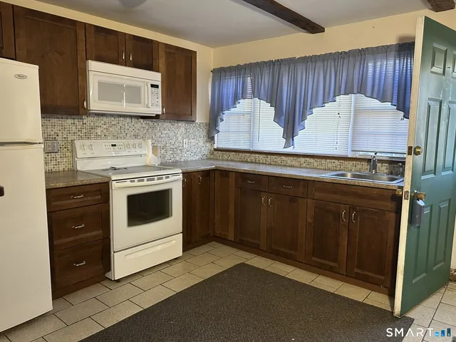 a kitchen with stainless steel appliances a stove a sink and a microwave