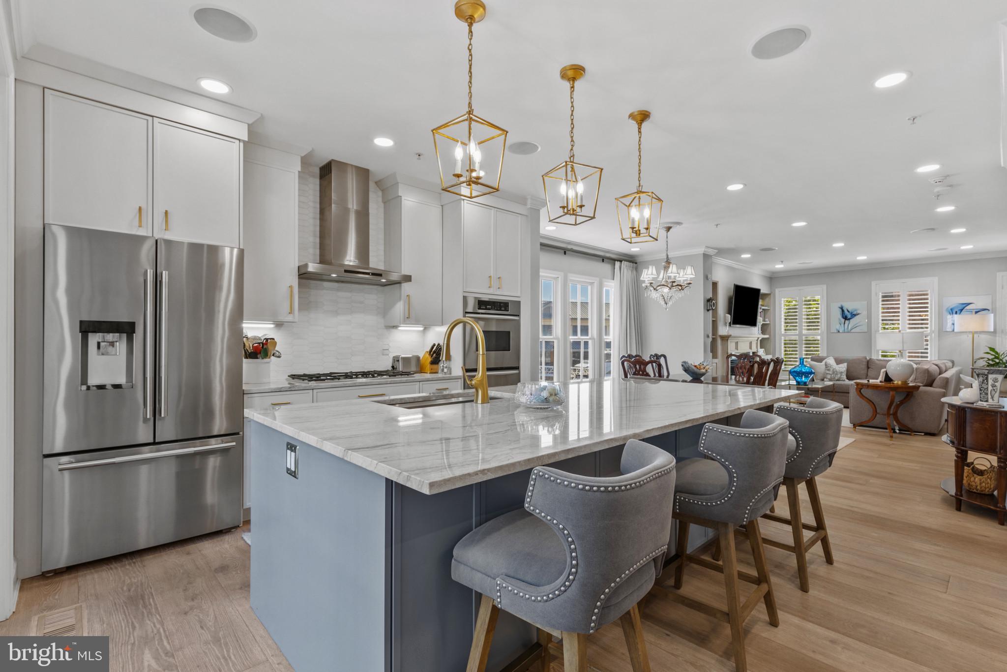 1262 Dockside Circle Baltimore, MD 21224 - Photo 5 of 35 a kitchen with stainless steel appliances granite countertop a sink a stove a refrigerator a center island a dining table and chairs