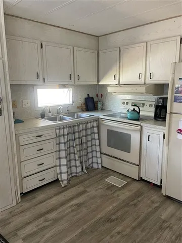 a kitchen with stainless steel appliances granite countertop a sink a stove and cabinets