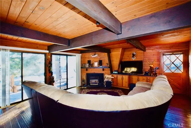 a living room with furniture a flat screen tv and floor to ceiling window