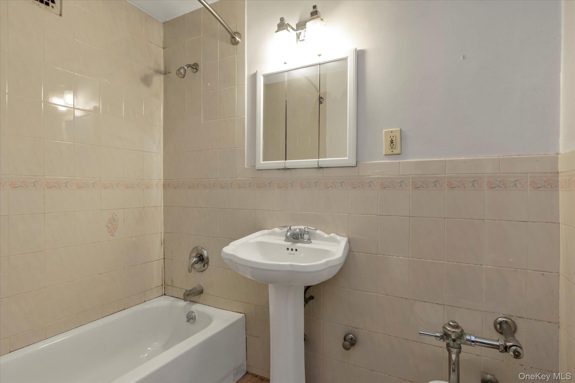 134-54 Maple Avenue, Unit 6M Queens, NY 11355 - Photo 11 of 15 a bathroom with a sink a mirror and a bathtub