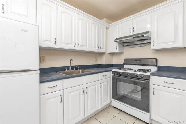 a kitchen with granite countertop white cabinets and stainless steel appliances