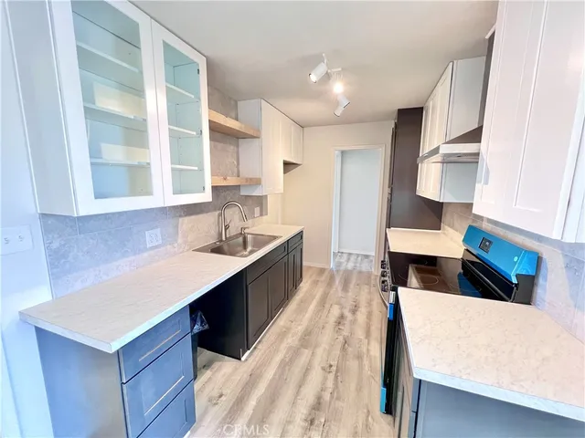 a large kitchen with kitchen island a sink stove and wooden cabinets