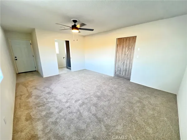 a view of a big room with closet and a chandelier fan