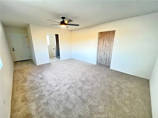 a view of a big room with closet and a chandelier fan
