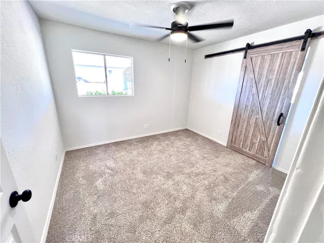 en empty room with windows and a ceiling fan